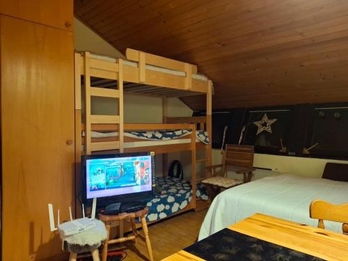 a bedroom with bunk beds and a desk with a computer at Cosy Rogla appartment 108 in Zreče