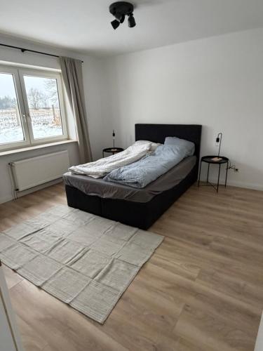 a bedroom with a bed and two windows at Ferienhaus Arlewatt in Arlewatt