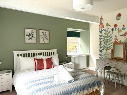 a bedroom with a bed and a desk and a mirror at The Malt House, Portree in Portree