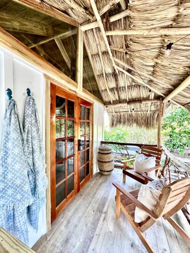 a room with a hammock and chairs on a house at Shipwreck Cove in Caye Caulker