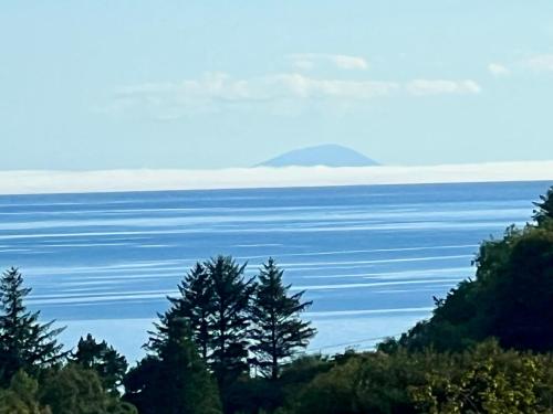 a view of the ocean with a mountain in the distance at Fintra Bay Hideaway in Killybegs