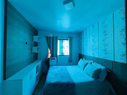 a bedroom with a bed with a blue light at Apartamento Mobiliado com internet e ar condicionado no centro in Cascavel