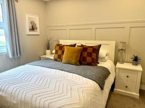 a bedroom with a bed with pillows on it at Holly Lodge - 2 x Kingsize bedrooms with private entrance and free parking-new shower room in Oban