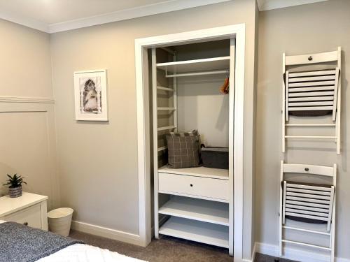 a bedroom with a closet with white shelves at Holly Lodge - 2 x Kingsize bedrooms with private entrance and free parking-new shower room in Oban