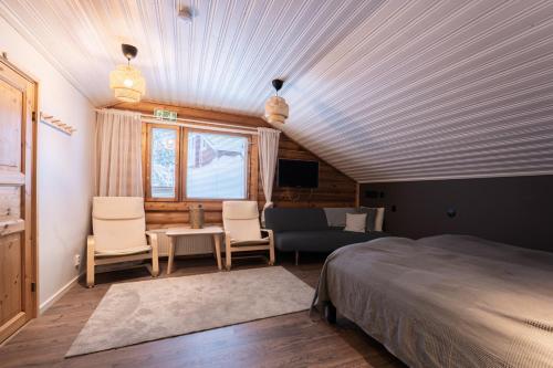 a bedroom with a bed and a living room at Levillenet Bearlodge at Levi city centre in Levi