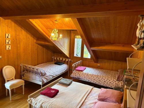 a attic room with two beds and a staircase at Les Bosquitos Chalet in Ax-les-Thermes