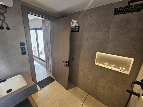a bathroom with a sink and a mirror and a door at شقق باطلالات بانوراميه in Riyadh