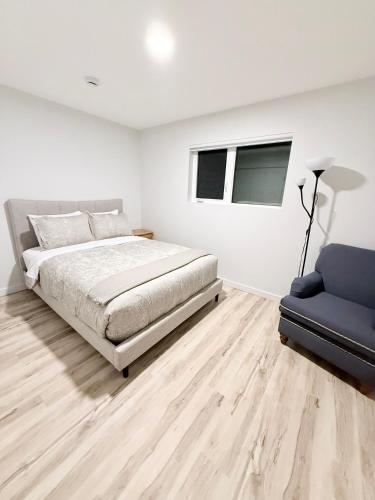 a bedroom with a bed and a blue chair at Private 1BR Suite with Kitchen, Laundry, Parking & 1 Gigabit Internet in Whitehorse