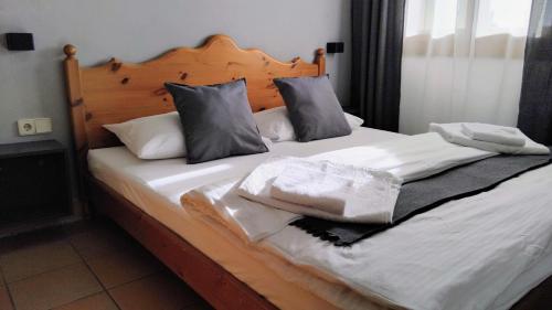 a bed with white sheets and pillows on it at GOOD Times Gerlitzen in Deutschberg