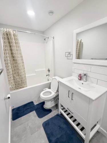 a white bathroom with a toilet and a sink at Private 1BR Suite with Kitchen, Laundry, Parking & 1 Gigabit Internet in Whitehorse