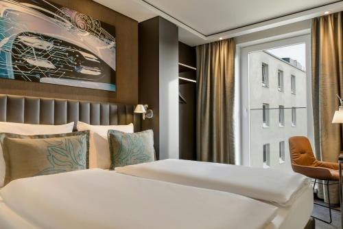 a hotel room with two beds and a window at Motel One Stuttgart-Feuerbach in Stuttgart
