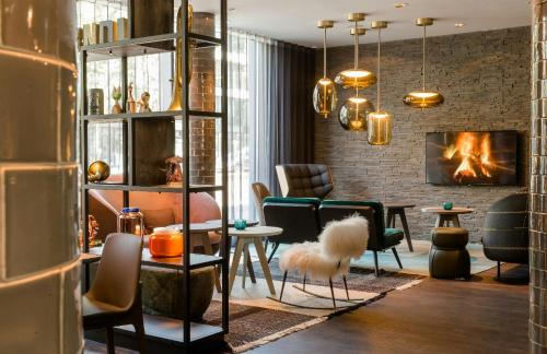 a living room with chairs and a fireplace at Motel One München-Westend in Munich