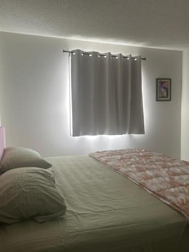 a bedroom with a large bed with a window at Cozy Vibe 2 bedroom Apartment in Edmonton