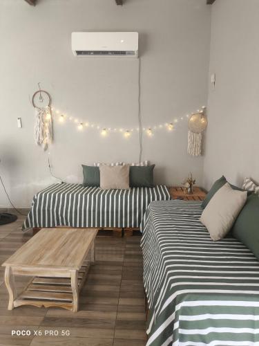 two beds and a bench in a room with lights at Quincho El Solar in Corrientes