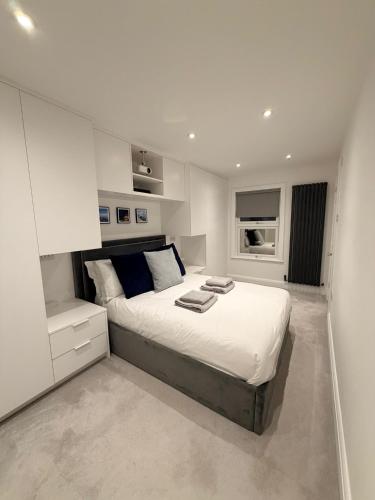 a white bedroom with a large bed in it at Adrian Cottage in Abbots Langley