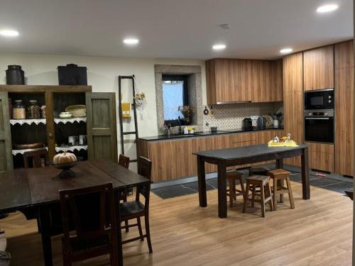 a kitchen with wooden cabinets and a table and chairs at New Honey House, Serra do Marão Ansiães-Amarante in Amarante