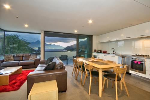Una cocina y una sala de estar con un sofá y una mesa. en Highview Central, en Queenstown