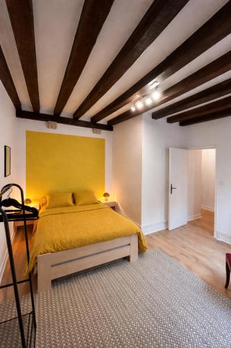 a bedroom with a large bed with a yellow wall at Loft Blois Cathédrale 2 Chambres in Blois