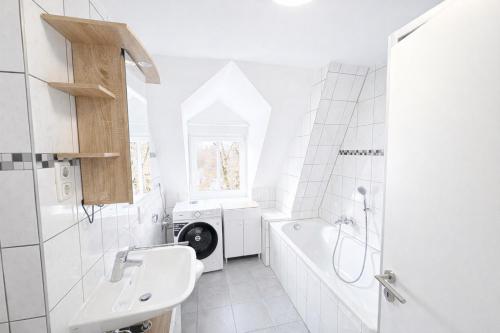 a white bathroom with a sink and a washing machine at LETA Homes - Komfortable FeWo mit Traumbalkon mit flexiblem, Self-Check-In & eigenen Parkplätzen in Straubing