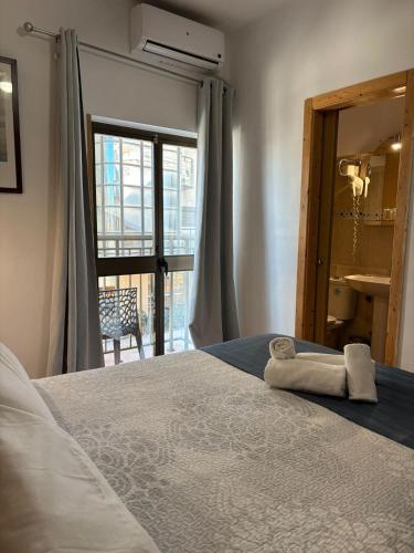 a bedroom with a bed with a towel on it at Guadalupe Hostal By Torremolinos On-line in Torremolinos
