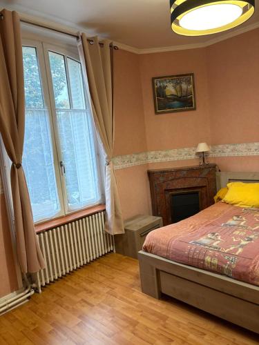 a bedroom with a bed and a large window at Entre Loire et Zoo Chambres d hôtes in Meusnes