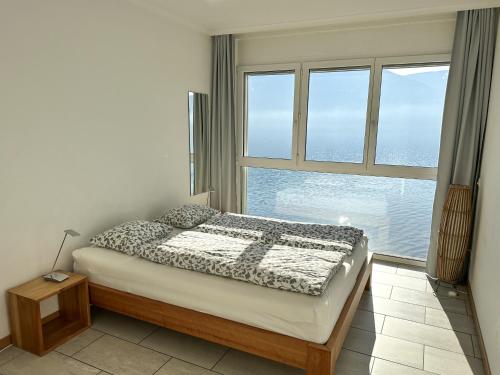 a bedroom with a bed and a large window at Residenza Acapulco II by Fewotessin in Moscia