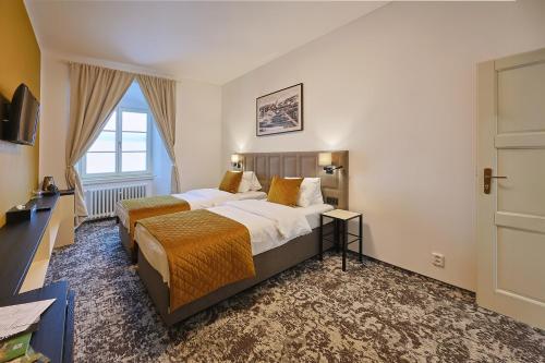 ein Hotelzimmer mit zwei Betten und einem Fenster in der Unterkunft Hotel Tynec in Týnec nad Sázavou
