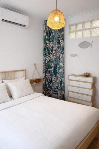 a bedroom with a white bed and a curtain at Townhouse with Rooftop Terrace in Olhão in Olhão