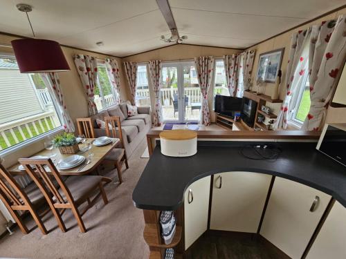 a kitchen and living room with a table and chairs at Southview Holiday park in Winthorpe