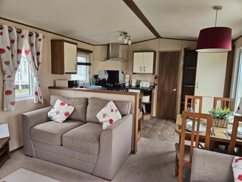 a living room with a couch and a kitchen at Southview Holiday park in Winthorpe