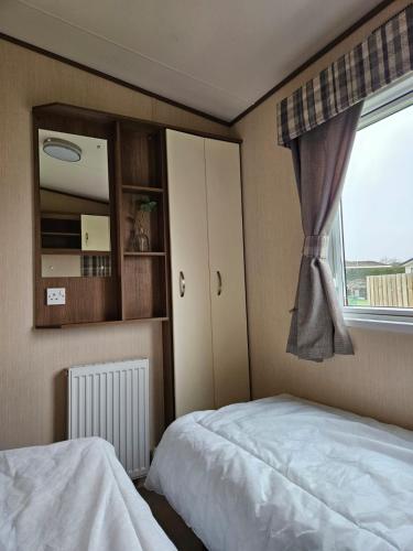 a bedroom with a bed and a window at Southview Holiday park in Winthorpe