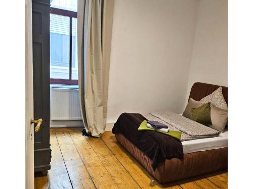a bedroom with a bed with a wooden floor and a window at Apartment für Monteure oder Reisende in Bad Camberg