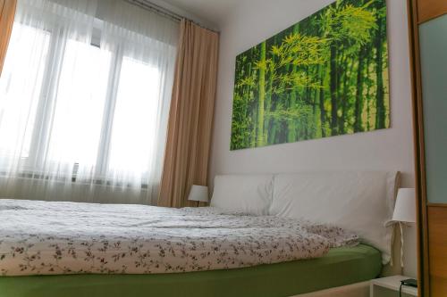 una camera da letto con un letto e un dipinto sul muro di Tomas's apartment a Lubiana