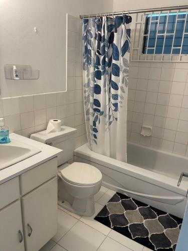 a bathroom with a toilet and a shower curtain at Peaceful Private Home With Exclusive Swimming Pool in Montego Bay