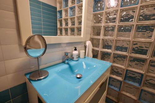a bathroom with a blue sink and a mirror at La abuela Pepa Fácil Aparcamiento in Mérida