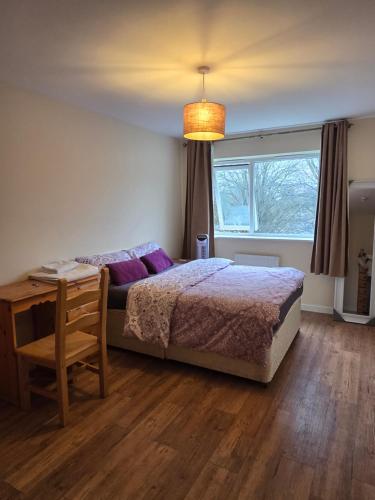 a bedroom with a bed and a table and a window at Highly Comfortable Home in Hatfield