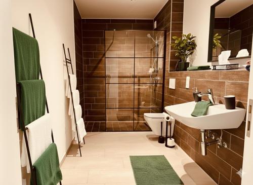 a bathroom with a toilet and a sink and a shower at Nivas Collection - Neubau Luxus Apartment in Montabaur