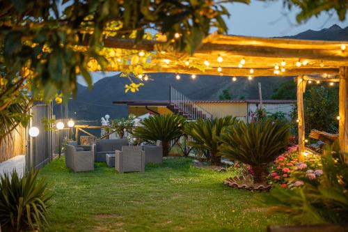 a backyard with a pergola with lights and plants at Agriturismo da Regina in Tramonti