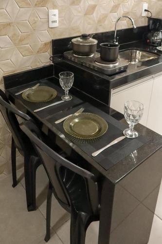 a kitchen counter with two plates and a sink at Aeroporto e praia Studio Casal in Vitória