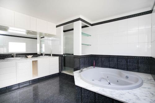 a white bathroom with a tub and a sink at Casa Baba in Palamós