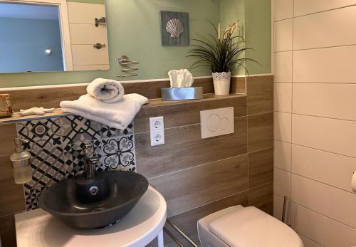 a bathroom with a black sink and a toilet at Gästezimmer am Lippesee - Apartements mit Küche - Perfekt für Langzeitaufenthalt in Paderborn