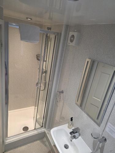 a bathroom with a shower and a sink at Glascoed Guest House in Llandudno