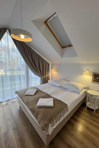 a bedroom with a large bed and a large window at Białe Tarasy in Rogowo