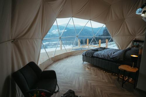 a room with a bed and a large window at Glamping Pod Hradom súkromné jacuzzi a sauna in Bardejov
