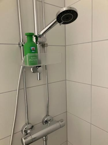 a shower with a green bottle on the wall at Yksiö Koulukadulla - autopaikka - Wi-Fi in Seinäjoki
