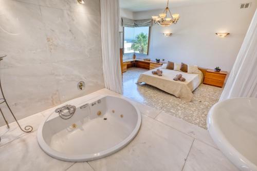 a large bathroom with a tub and a couch at Luxurious Villa with pool in Il-Mielaħ