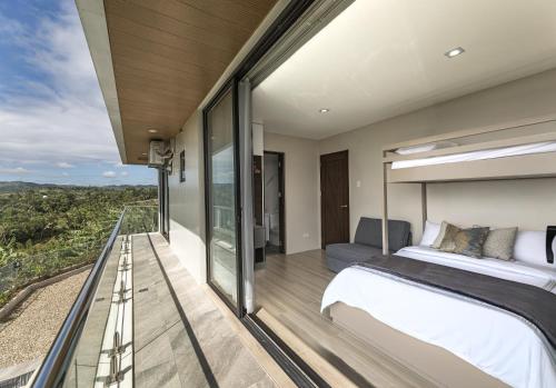 a bedroom with a bed and a balcony at Villa 360 in Calaca