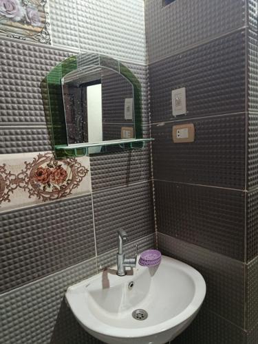 a bathroom with a sink and a mirror at Rooma ka Guest House in Aswan