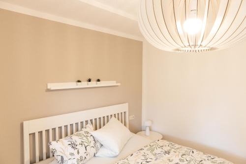 a bedroom with a white crib and a chandelier at Hohenlupfenblick in Stühlingen