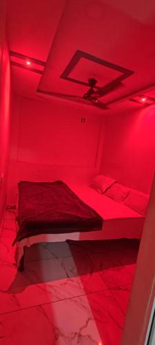 a red room with a bed with a red light at Hotel Mannat palace in Ujjain